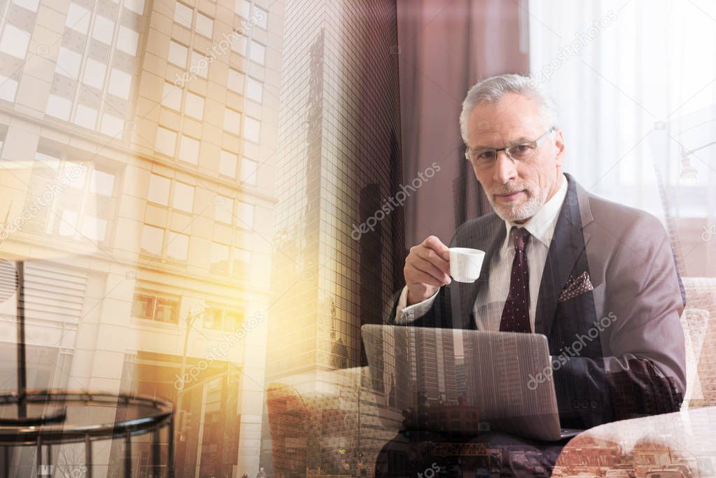 Mature businessman taking break and drinking coffee