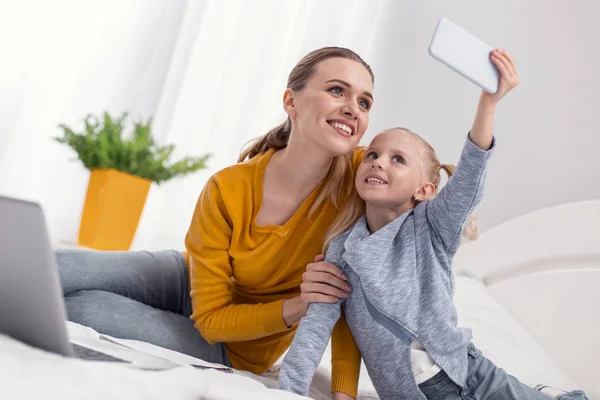 Positive sincere woman and girl taking selfie