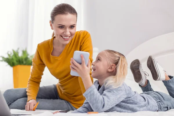 Vidám vidám nő és lány segítségével a telefon — Stock Fotó