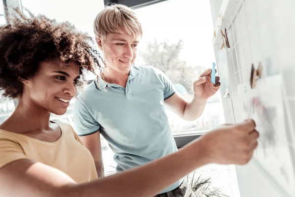 Positive nette Menschen, die auf das Whiteboard schauen — Stockfoto