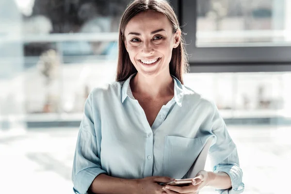 Mujer feliz alegre sosteniendo su teléfono inteligente — Foto de Stock