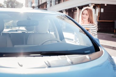 Ayakta ve arabasını bakan çok hoş kadın.