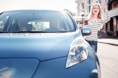 Ayakta ve el sallayarak genç güzel kadın.