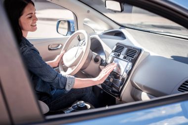 Denetim Masası'na dokunarak ve gülümseyen memnun genç kadın.