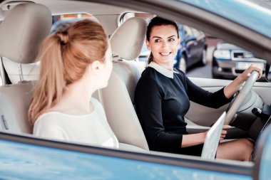 Helm tarafından oturan ve gülümseyen kendine güvenen güzel kadın.