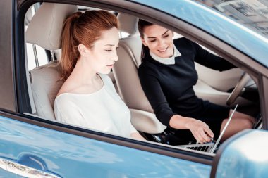 Oturma ve dizüstü bilgisayar kullanarak ciddi kadın işgal.