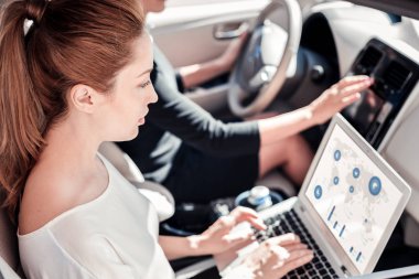 Arabada olmak dizüstü bilgisayar ile çalışan meşgul akıllı kadın.