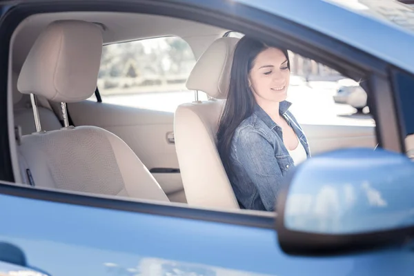 Agradável mulher bonita sorrindo e sentado no carro . — Fotografia de Stock