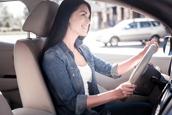 Joyful confident woman holding by the helm and smiling. — Stock Photo, Image