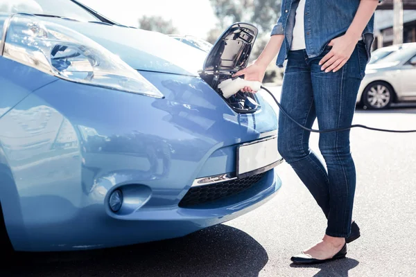 Genç akıllı kadın ayakta ve şarj Gadget'ı kullanma.