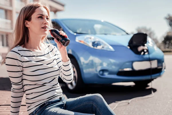 Bardzo spokojna kobieta siedzi i picie cola. — Zdjęcie stockowe