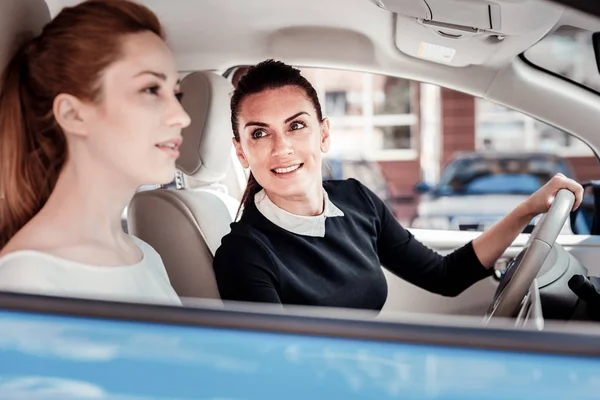 Interested pleasant woman looking at her friend and smiling. — Stock Photo, Image