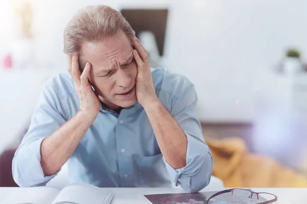 Müder, fröhlicher Mann, der unter Kopfschmerzen leidet — Stockfoto