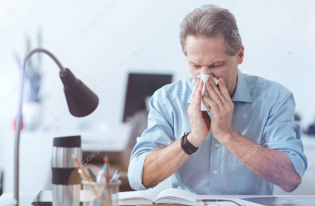 Cheerless depressed man having a running nose