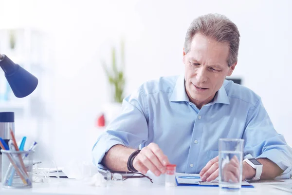 Agradable hombre agradable sentado a la mesa — Foto de Stock