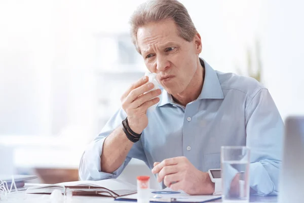 Un hombre irreflexivo y alegre usando un pañuelo de papel — Foto de Stock