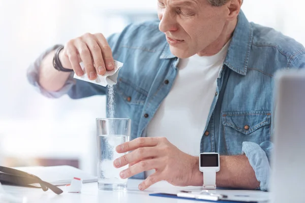 Unhappy ill man preparing his medicine — Stock Photo, Image