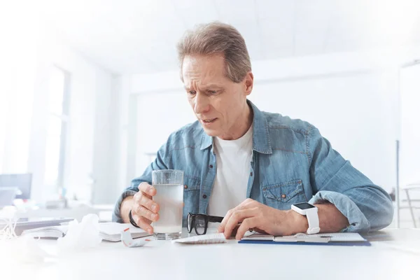 Hombre malhumorado infeliz mirando en un vaso —  Fotos de Stock