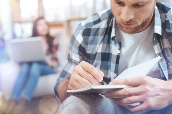 Nahaufnahme eines aufmerksamen Mannes, der Notizen macht — Stockfoto