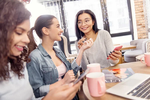 Gelukkig drie studenten beslissen op muziek voor presentatie — Stockfoto