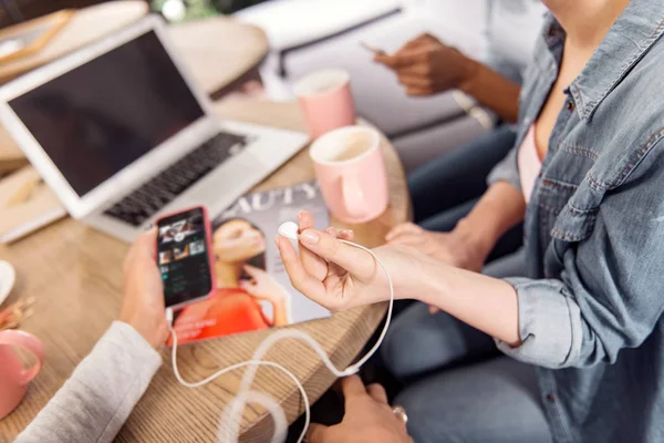 Mani femminili lisce che tengono cuffie e telefono — Foto Stock