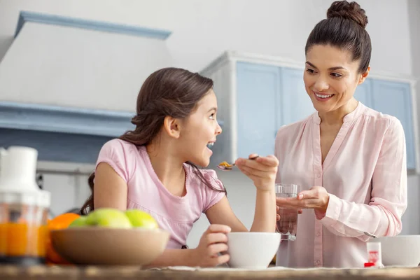 Innehåll mor ger vitaminer till hennes dotter — Stockfoto