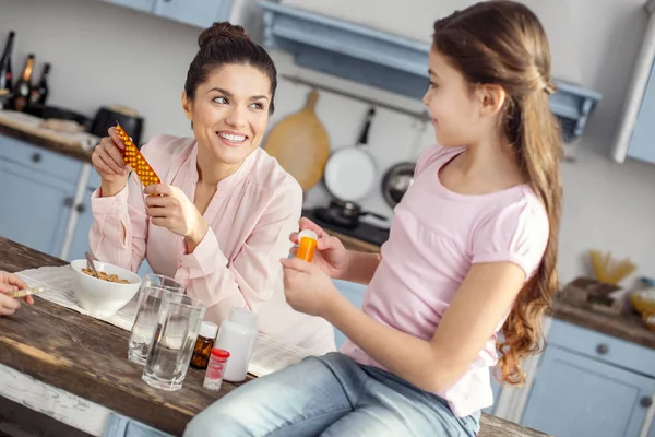 Örömteli anya beszél vitaminok az ő kedves lány — Stock Fotó