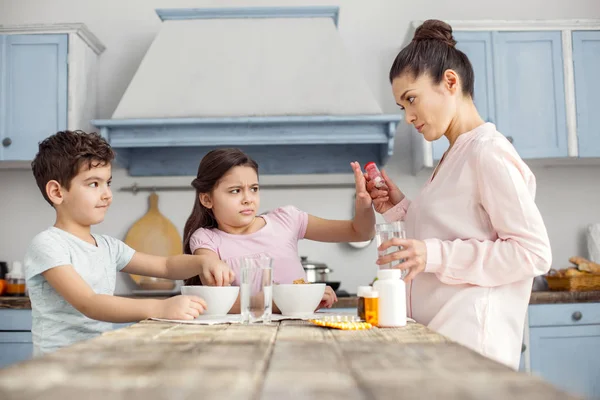 Dissatisfied girl refusing taking vitamins — Stock Photo, Image