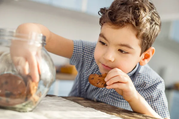 Усміхнений маленький хлопчик їсть печиво — стокове фото