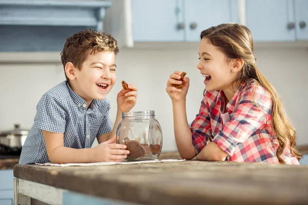 Niños riéndose tomando algunas galletas — Foto de Stock