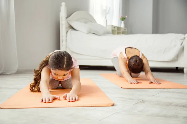 Concentrat fata face exerciții cu mama ei — Fotografie, imagine de stoc