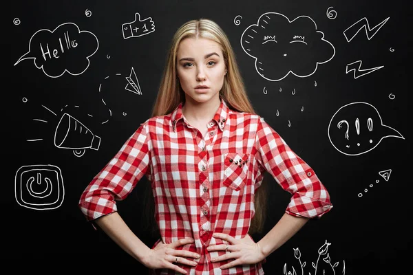 Serious student standing with hands on her hips and thinking — Stock Photo, Image