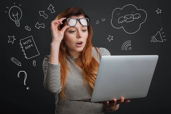 Estudiante emocional poniendo sus gafas mientras mira la pantalla —  Fotos de Stock