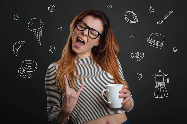 Emotionale Frau schließt beim Kaffeetrinken die Augen und singt — Stockfoto