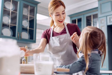 Neşeli anne ve küçük kızı pişirme sırasında bağ