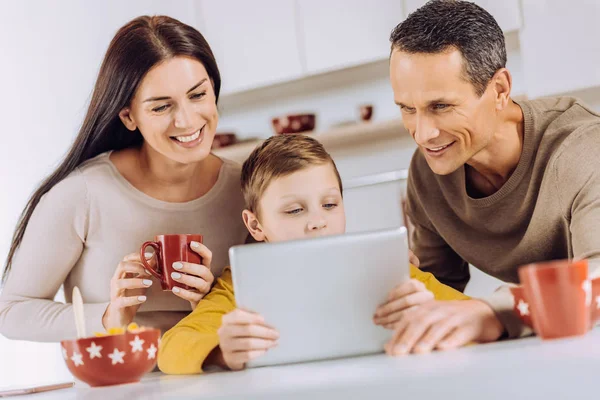Familia feliz viendo vídeo en la tableta juntos — Foto de Stock