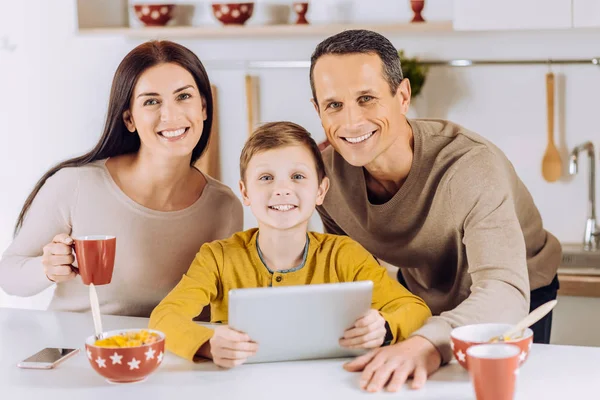 Glad familj poserar medan du tittar på video på surfplatta — Stockfoto
