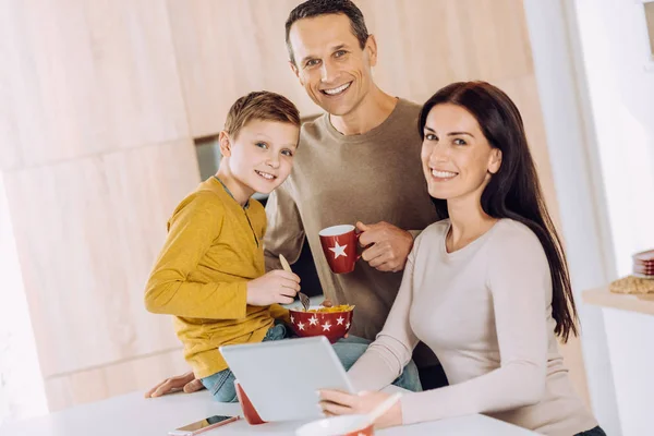 Familia alegre posando mientras desayuna —  Fotos de Stock