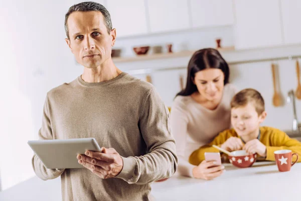 Ernstige jonge man poseren met de tablet in de keuken — Stockfoto