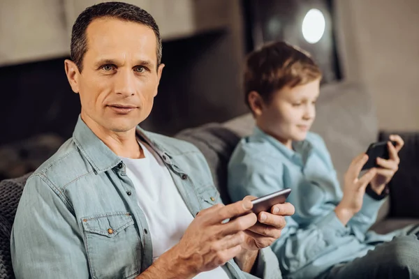 Agradable hombre posando mientras juega en el teléfono — Foto de Stock