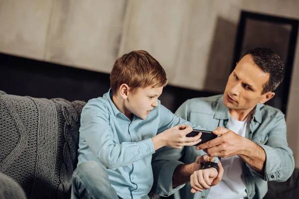 Irritados padre e hijo peleando por un teléfono —  Fotos de Stock