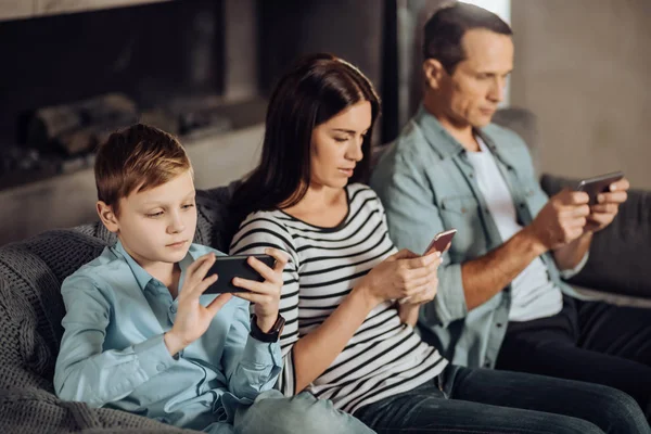 Agradable familia joven ser adicto a sus teléfonos —  Fotos de Stock