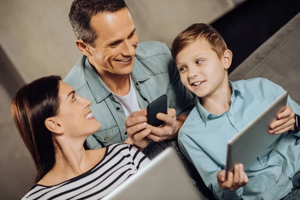 Joven familia charlando mientras usa sus gadgets —  Fotos de Stock