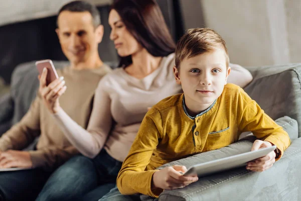 Niño encantador posando mientras juega en la tableta — Foto de Stock