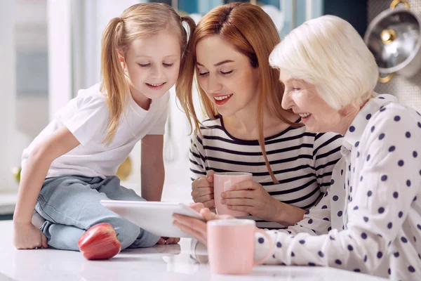 Três gerações de mulheres assistindo vídeo no tablet — Fotografia de Stock