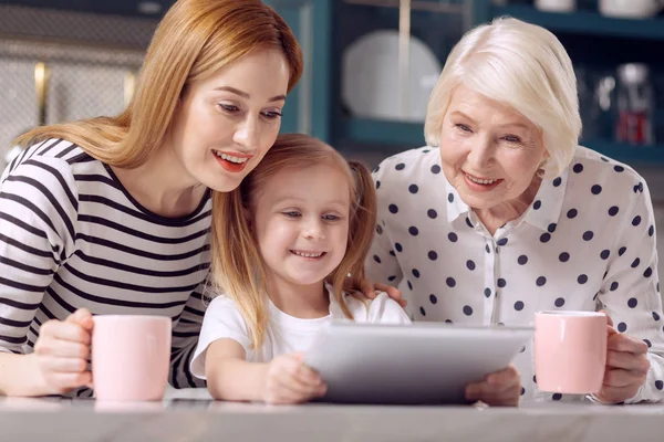 Aranyos lány mutatja videóinak anya és nagymama tabletta — Stock Fotó