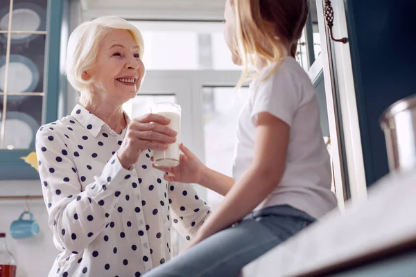 Meisje accepteren glas melk van oma — Stockfoto