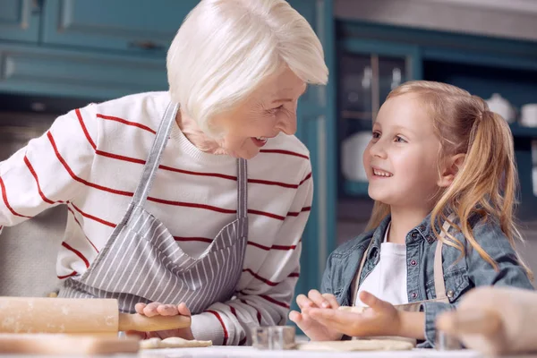 Nagymama és unokája megvitatása cookie-gyártás — Stock Fotó