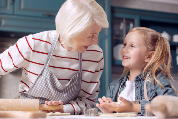 Grandmother and granddaughter discussing cookie-making