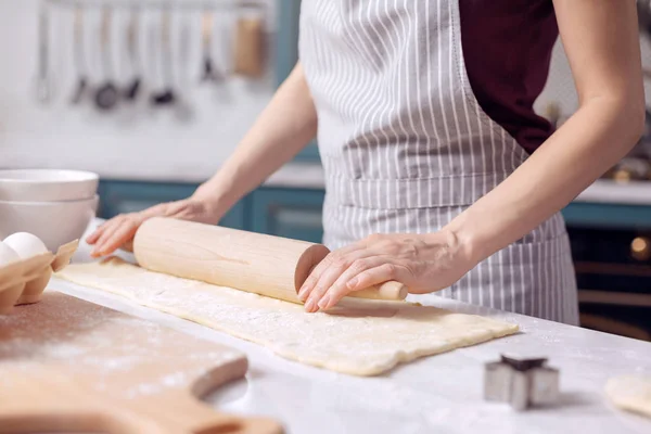 Женские руки раскатывают тесто для печенья — стоковое фото